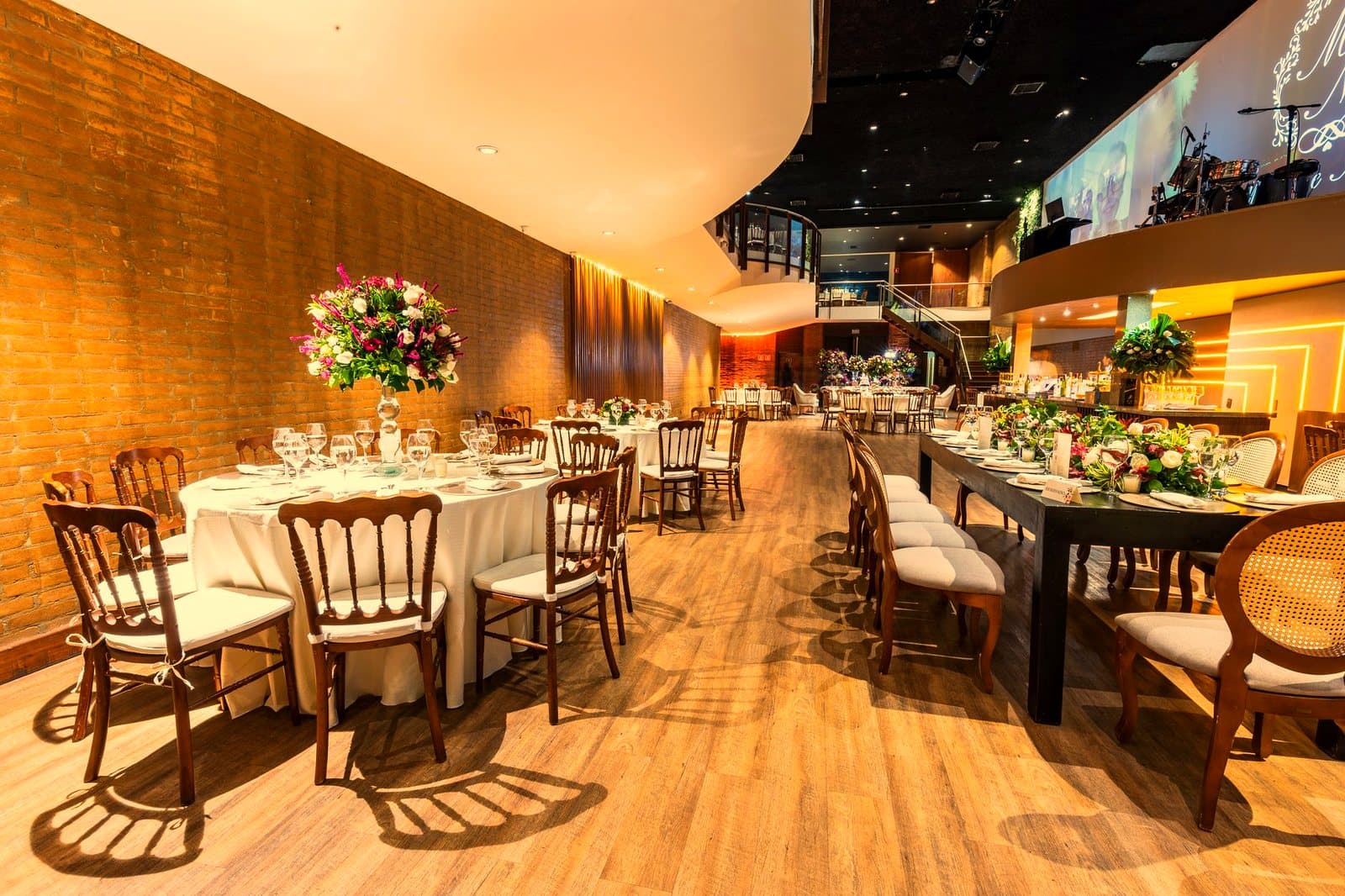 Luxurious wedding hall set for a reception with elegant table arrangements and floral decor.