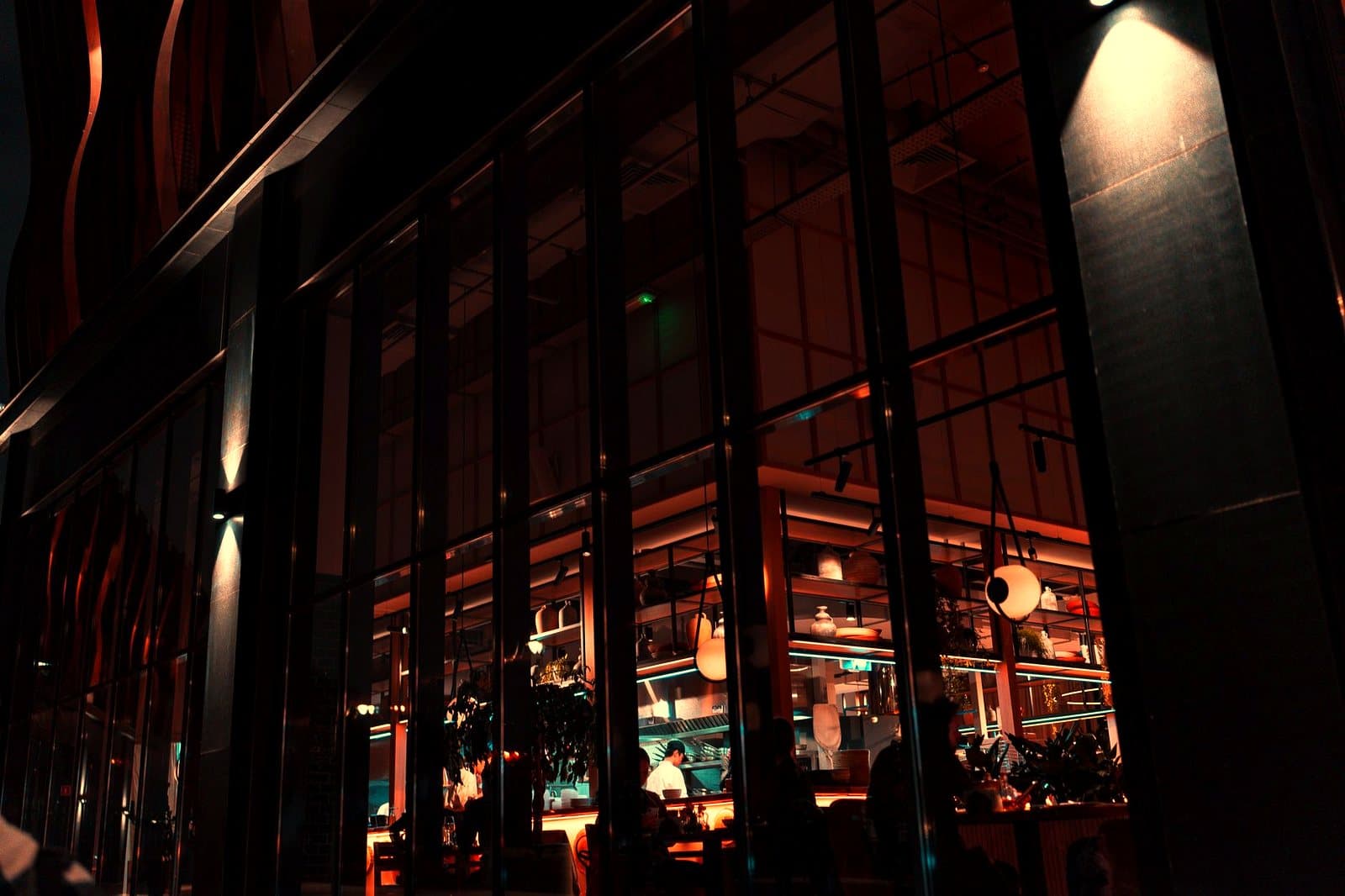 The exterior of a stylish urban restaurant lit up at night