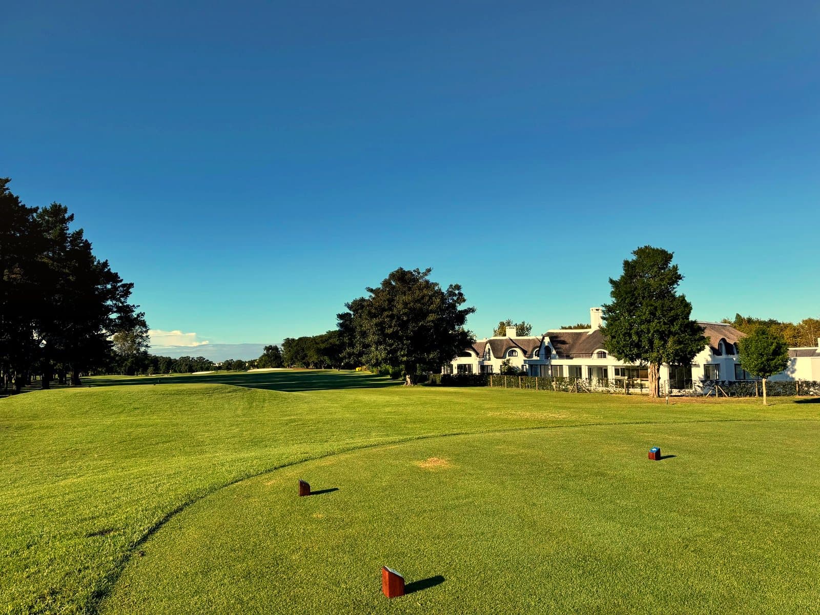 A manicured golf course fairway running up toward a clubhouse