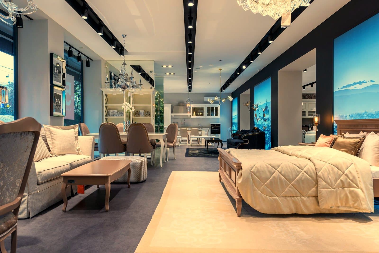 Interior of spacious furniture store with classic styled bed with coverlet and cushions placed in front of soft couch an