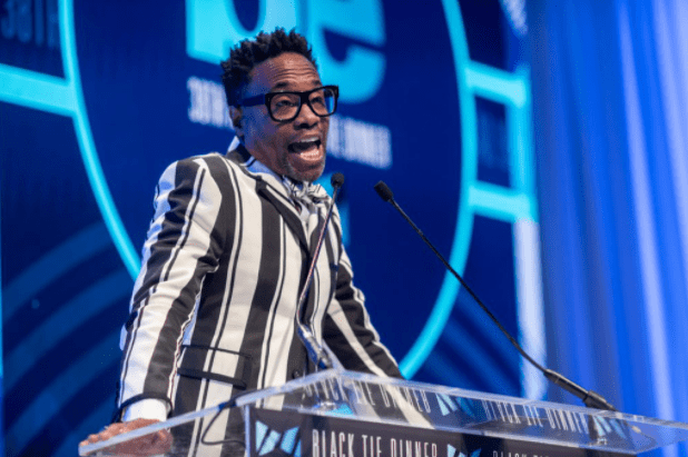 Billy Porter wearing striped suit talking to audience
