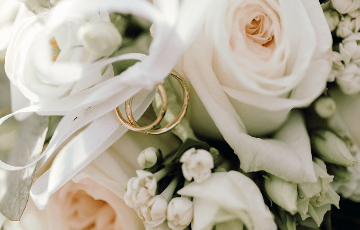 close-up of pink rose wedding bouquet with gold wedding rings