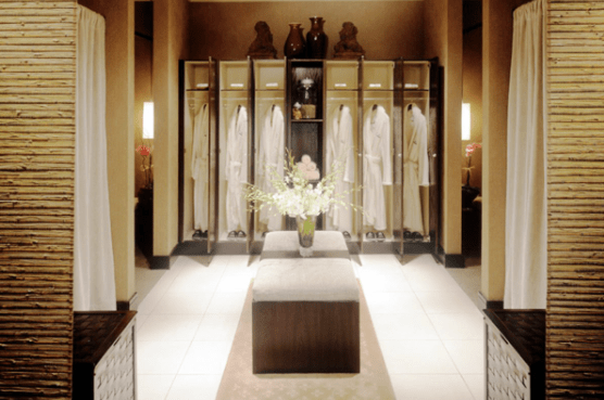 Nordstrom spa room with cushions and white robes hanging in closet